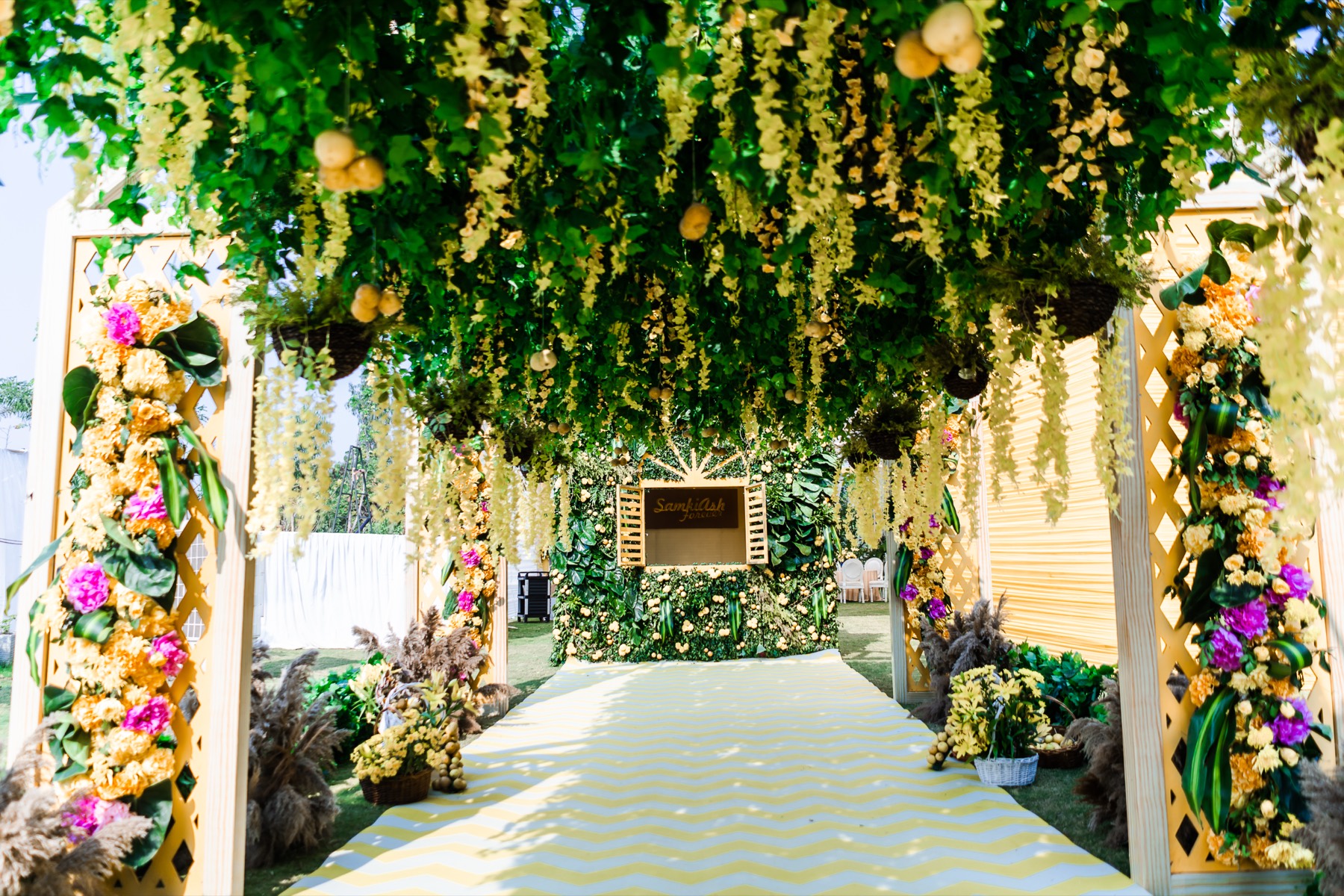 A floral entrance pathway of marigold and orchid pillars