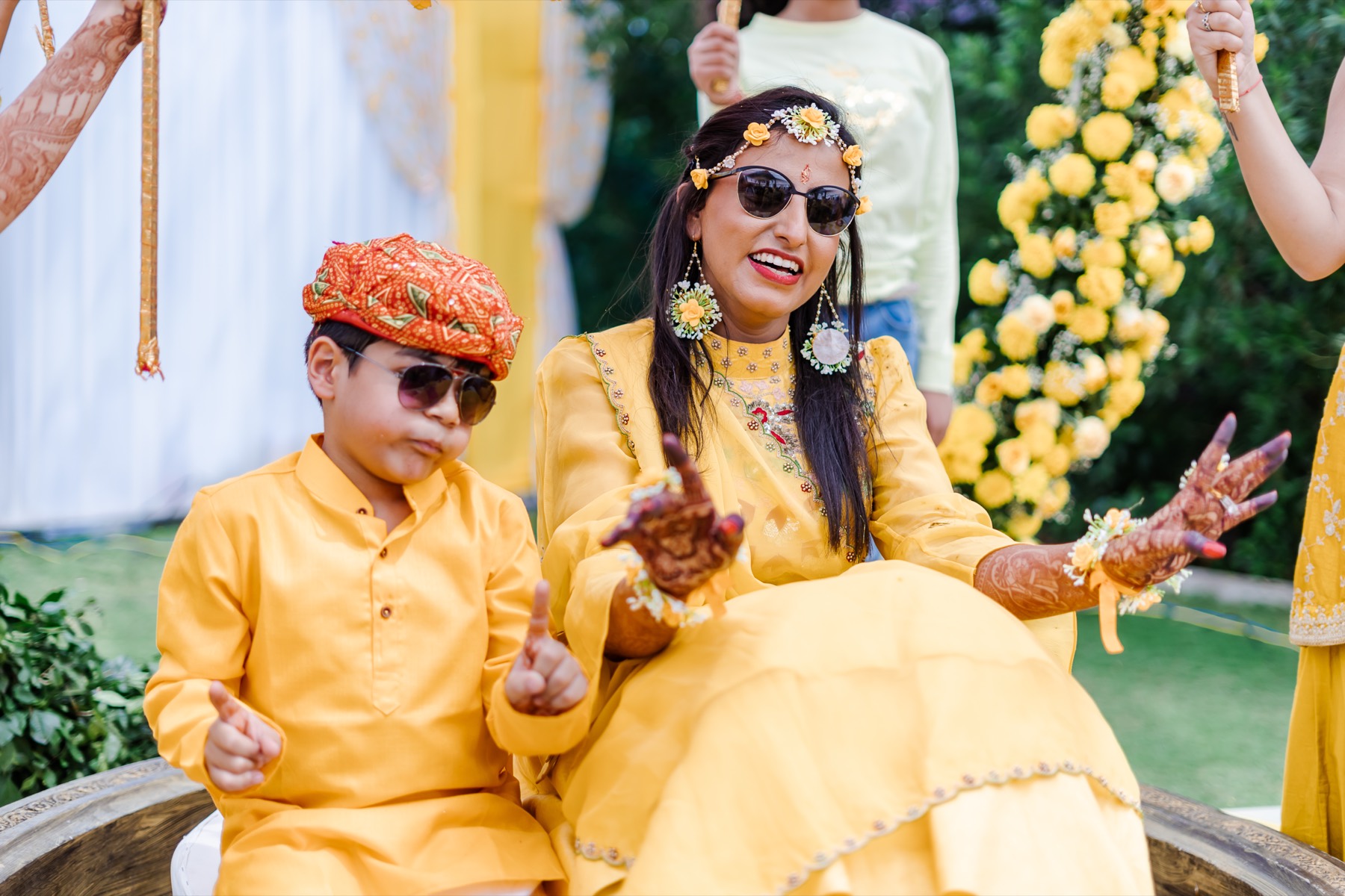 Guests in yellow singing and clapping at the haldi ceremony