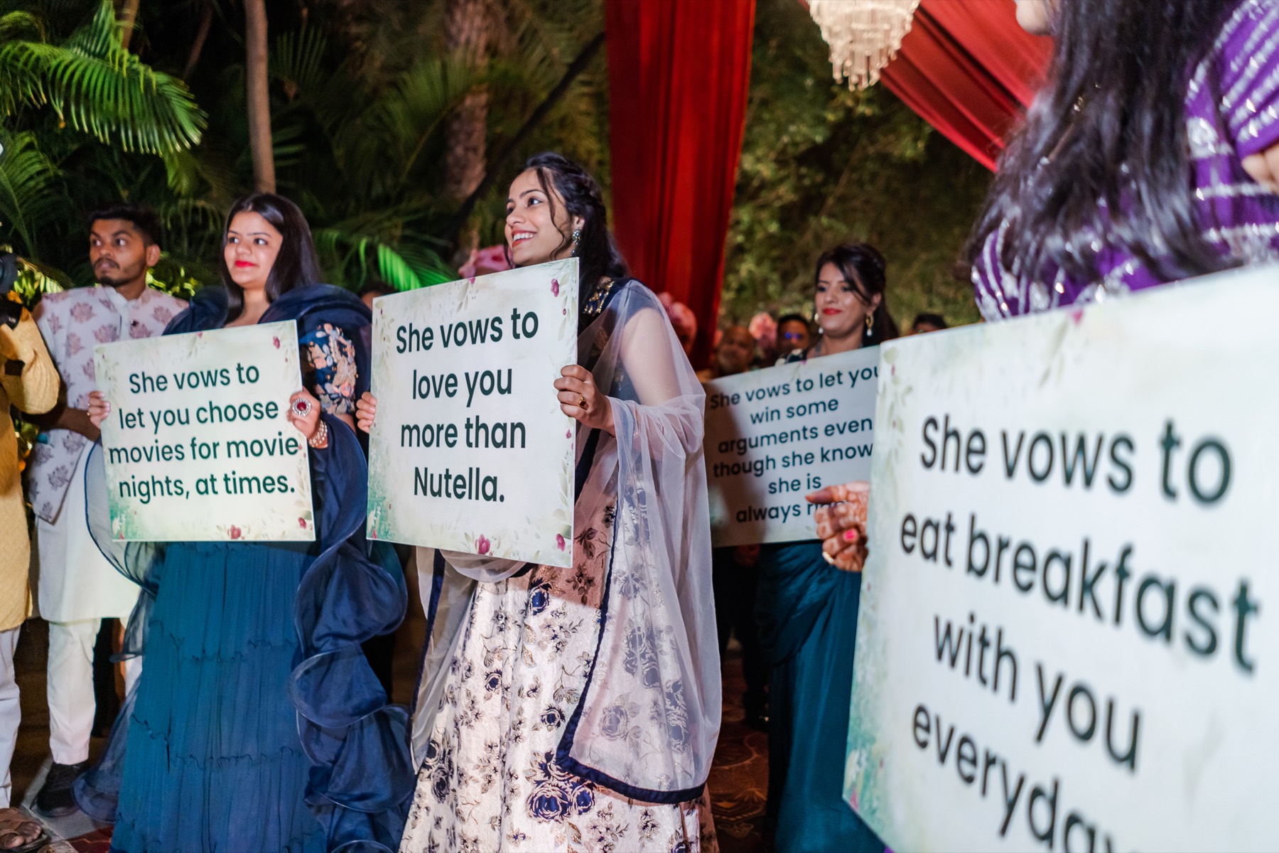 Bridesmaids holding hand-painted vow placards