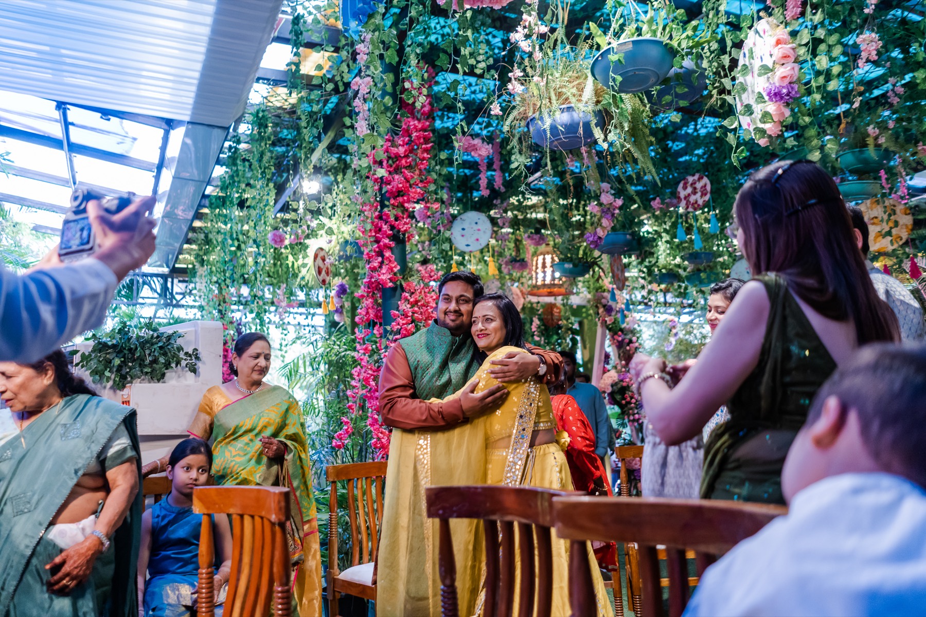 Family exchanging blessings under hanging flowers