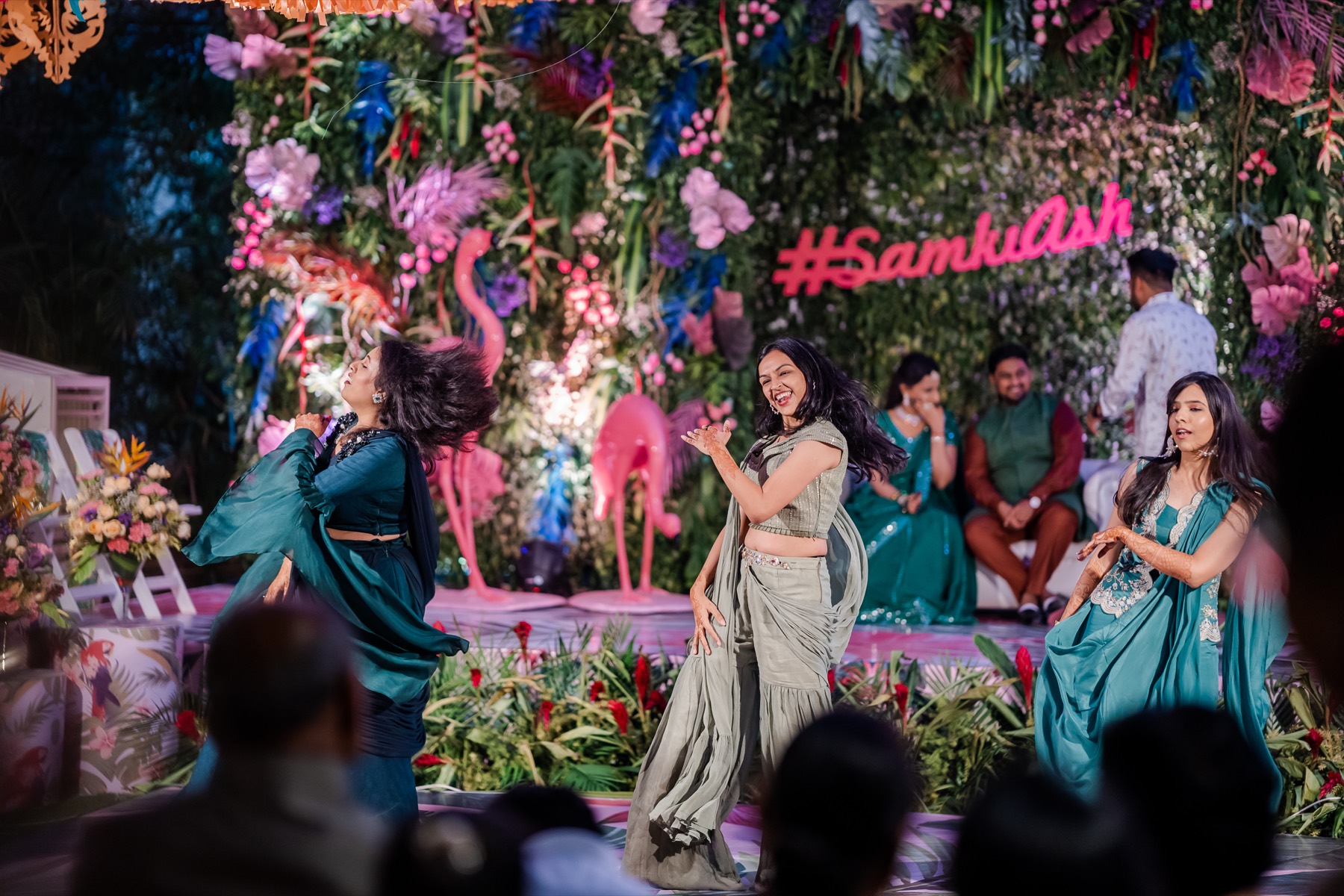Dancers performing in teal silk before a stage