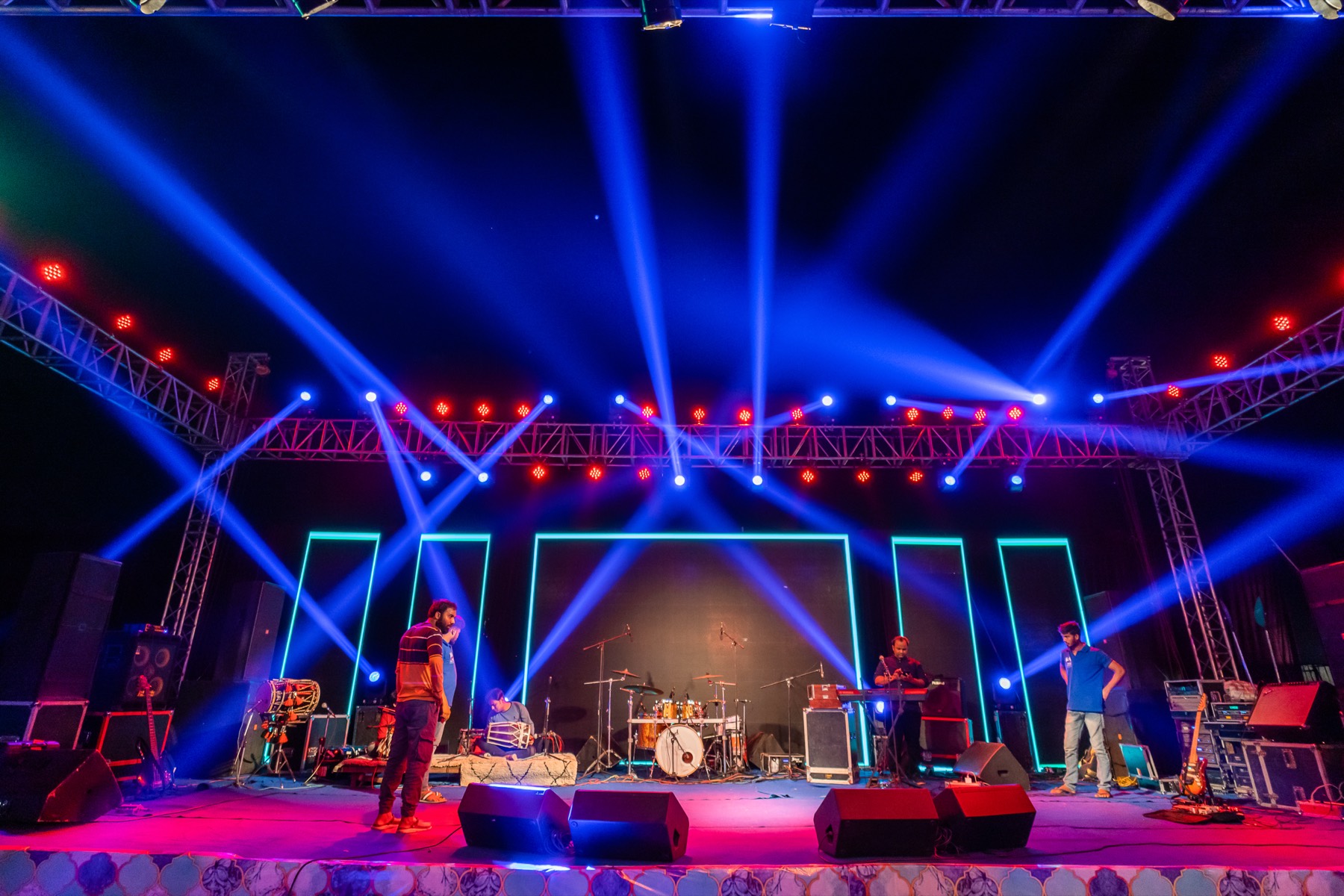 A wide concert stage flooded with blue and red lights