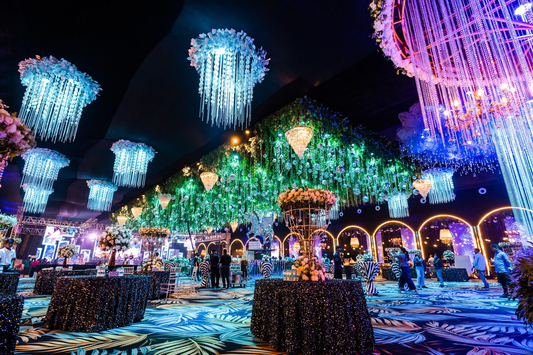 A reception hall strung with crystal chandeliers and hanging greenery