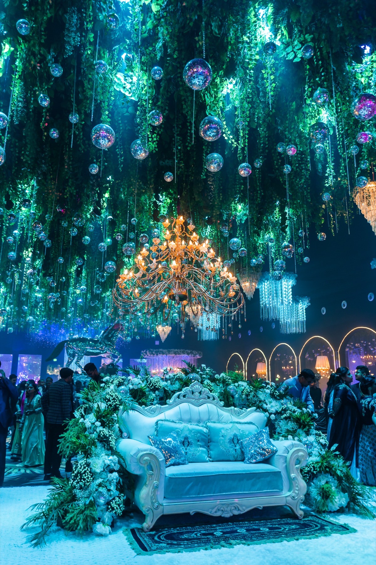 An ornate seating throne beneath beaded chandeliers
